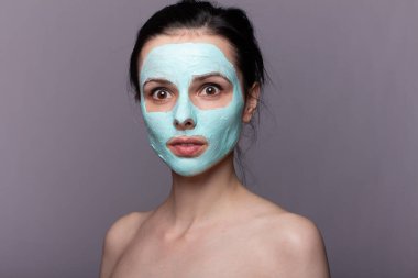 Kozmetik maskeli kadın, sorunlu cilt, gri arka plan