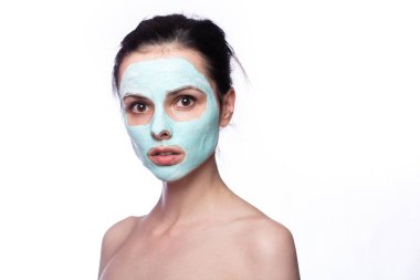 Yüzünde kozmetik maskeli kadın, beyaz arka plan.