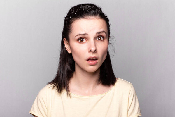 funny woman with yellow t-shirt, gray background, emotional portrait