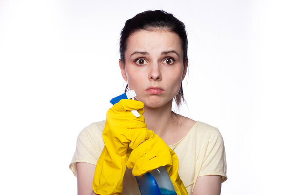 beautiful cleaning service woman in yellow cleaning gloves holds a fucking window cleaner in her hands