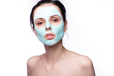 Yüzünde kozmetik maskeli kadın, beyaz arka plan.