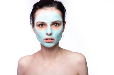 Yüzünde kozmetik maskeli kadın, beyaz arka plan.