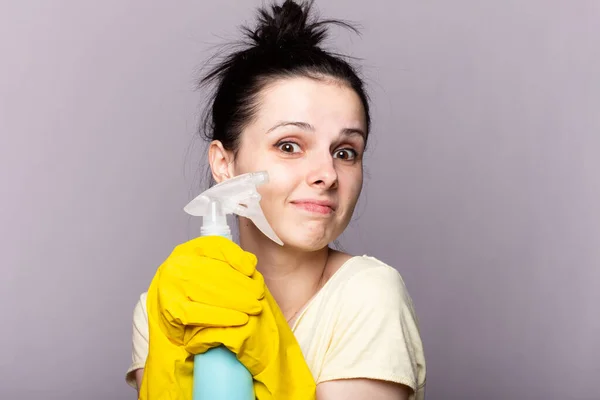 Spring cleaning woman ready for spring cleaning smiling with rubber gloves and cleaning products.