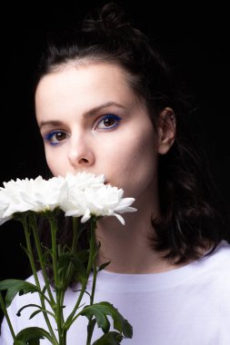 Koyu arkaplanda beyaz çiçekli güzel bir kadın