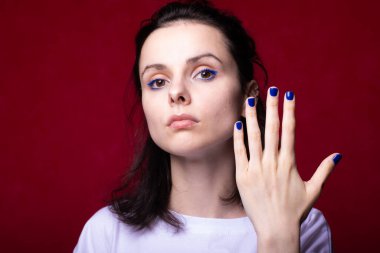 Kırmızı arka planda açık renk tişörtlü güzel bir kız.