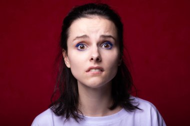 Güzel kadın yüz yapar, kırmızı arkaplan.