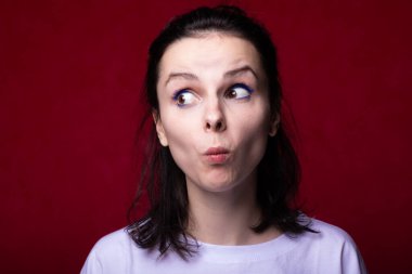 Güzel kadın yüz yapar, kırmızı arkaplan.