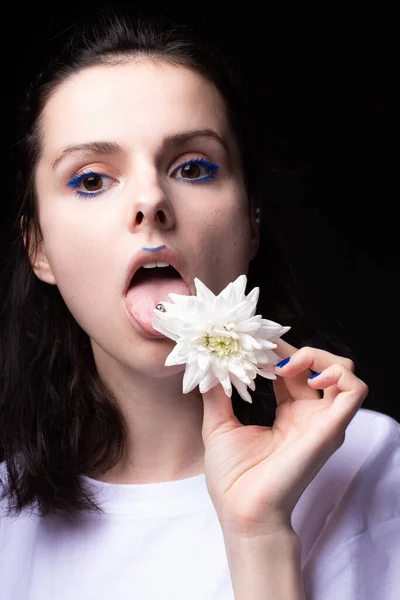 woman eating white flowers on black background