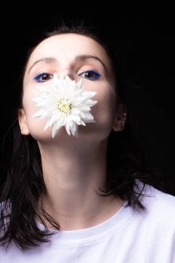 Siyah arka planda kasımpatı olan kadın.