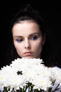 Elinde bir buket kasımpatı olan bir kadın.