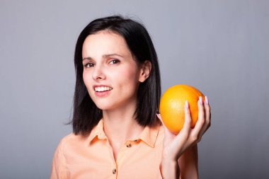 Elinde greyfurt tutan bir kadın.