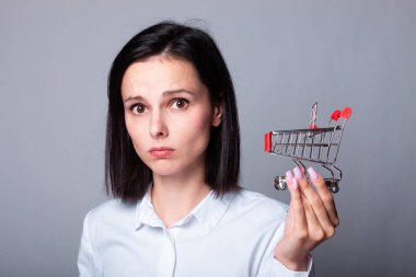 Elinde küçük bir market arabası olan güzel bir kadın.