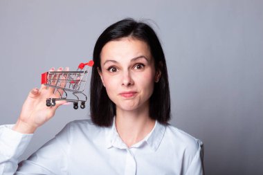 Küçük alışveriş arabalı bir kadın. Alışveriş arabasıyla yakışıklı bir adam çarpıştı. İndirim, indirim ve online alışveriş konsepti. Küçük alışveriş arabası olan kız. Boşluğu kopyala