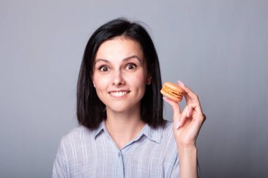 Kadın elinde kurabiye tutuyor.