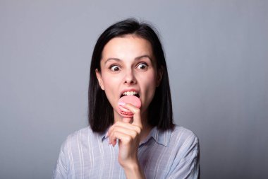 Kadın elinde kurabiye tutuyor.