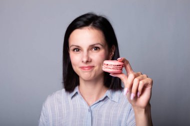 Kadın elinde kurabiye tutuyor.