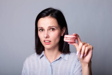 Kadın elinde kurabiye tutuyor.