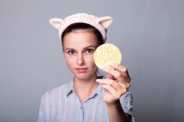 Süngerli, gri arkaplan, ped sorunu olan bir kadın...