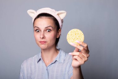 Süngerli, gri arkaplan, ped sorunu olan bir kadın...