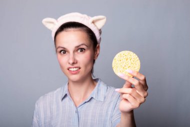 Süngerli, gri arkaplan, ped sorunu olan bir kadın...