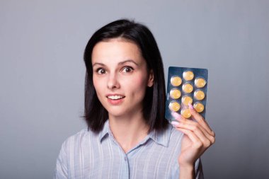 Güzel genç kız öksürüğe karşı lolipop tutuyor.