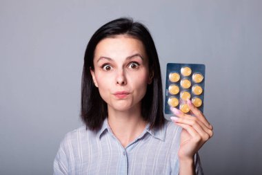 Güzel genç kız öksürüğe karşı lolipop tutuyor.