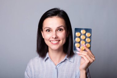 Güzel genç kız öksürüğe karşı lolipop tutuyor.