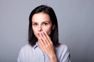 Gri arka planda gri tişörtlü güzel kız.