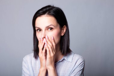 Mor gömlekli esmer bir kadın elini yüzüne dayadı.