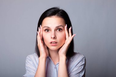 Gri arka planda tişörtlü güzel kız. 