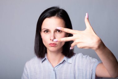 Kadın tırnaklarını gösteriyor, gri stüdyo geçmişi var.