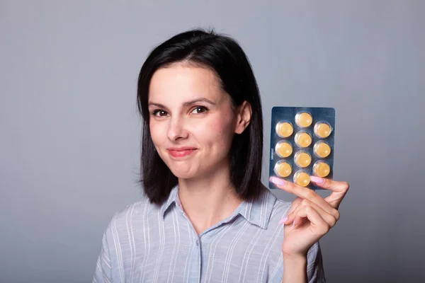 woman holding a package of pills in her hand