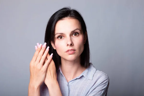 woman showing her hands, gray studio background