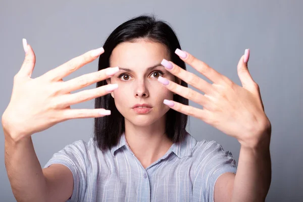 woman showing her hands, gray studio background