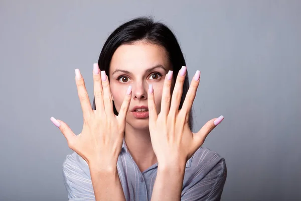 woman showing her hands, gray studio background