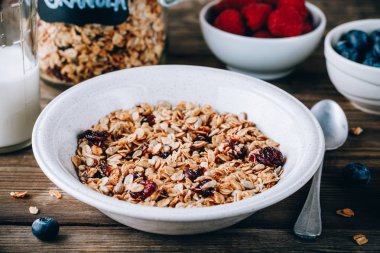 Yulaf ve fındık ve kuru cranberries ile organik ev yapımı granola tahıl. Sağlıklı kahvaltı süt ve çilek ile.