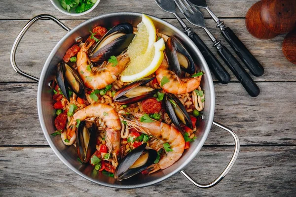 西班牙海鲜饭与贻贝 虾和香肠香肠在传统的平底锅在木质背景 顶部视图 — 图库照片