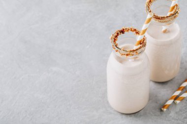 Vanilyalı kurabiye milkshake gri bir arka plan üzerinde cam şişelerde