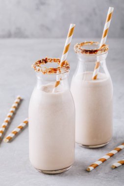 Vanilyalı kurabiye milkshake gri bir arka plan üzerinde cam şişelerde