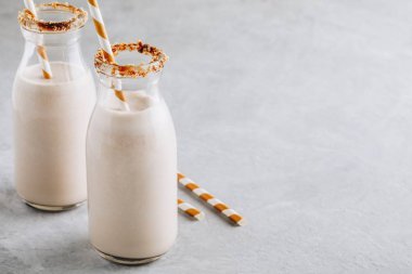 Vanilyalı kurabiye milkshake gri bir arka plan üzerinde cam şişelerde