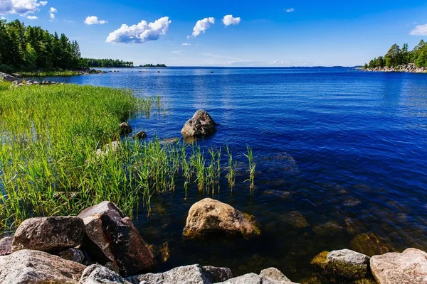石と農村のフィンランドの日当たりの良い夏の日の緑の森と清流青湖 — ストック写真