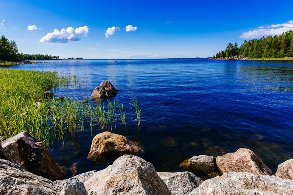 石と農村のフィンランドの日当たりの良い夏の日の緑の森と清流青湖 — ストック写真