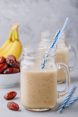 Muz ve tarihi meyve yüzlü veya milkshake cam mason kavanoza gri taş zemin üzerine