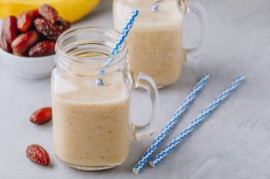 Muz ve tarihi meyve yüzlü veya milkshake cam mason kavanoza gri taş zemin üzerine