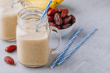 Muz ve tarihi meyve yüzlü veya milkshake cam mason kavanoza gri taş zemin üzerine