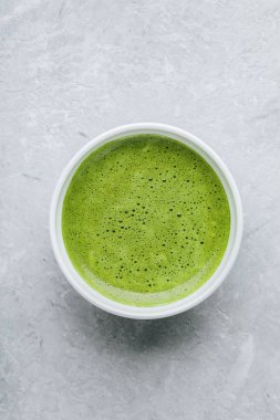 Japon matcha yeşil çay kahve gri taş zemin üzerine beyaz kase. Üstten görünüm