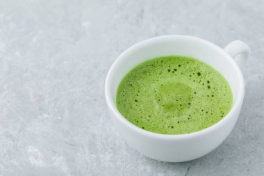Japon matcha yeşil çay kahve gri taş zemin üzerine beyaz Kupası. 