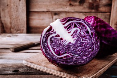 Cutted fresh organic red cabbage on wooden background clipart