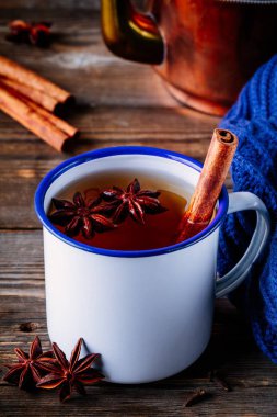 Baharat tarçın ve koyu ahşap arka plan üzerinde mug içinde anason ile Sonbahar sıcak çay