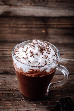 Ahşap rustik arka plan üzerine bir bardak krem şanti ile sıcak çikolata meşrubatının